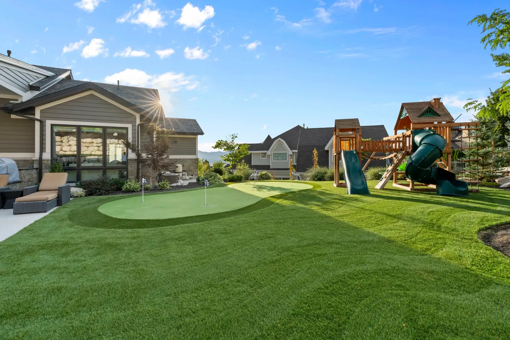 Backyard putting green, playground, and patio at a DFW home